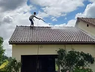 Image d'une personne nettoyant un toit de maison